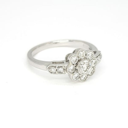 Diamond Daisy Cluster Ring; central brilliant cut diamond surrounded by eight further diamonds, accented with two diamonds on each shoulder, in 18ct white gold