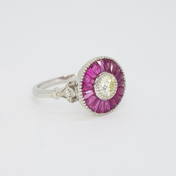 Ruby and Diamond Cluster Target Ring; featuring a central round brilliant-cut diamond surrounded by calibre-cut rubies, in platinum with millegrain edging