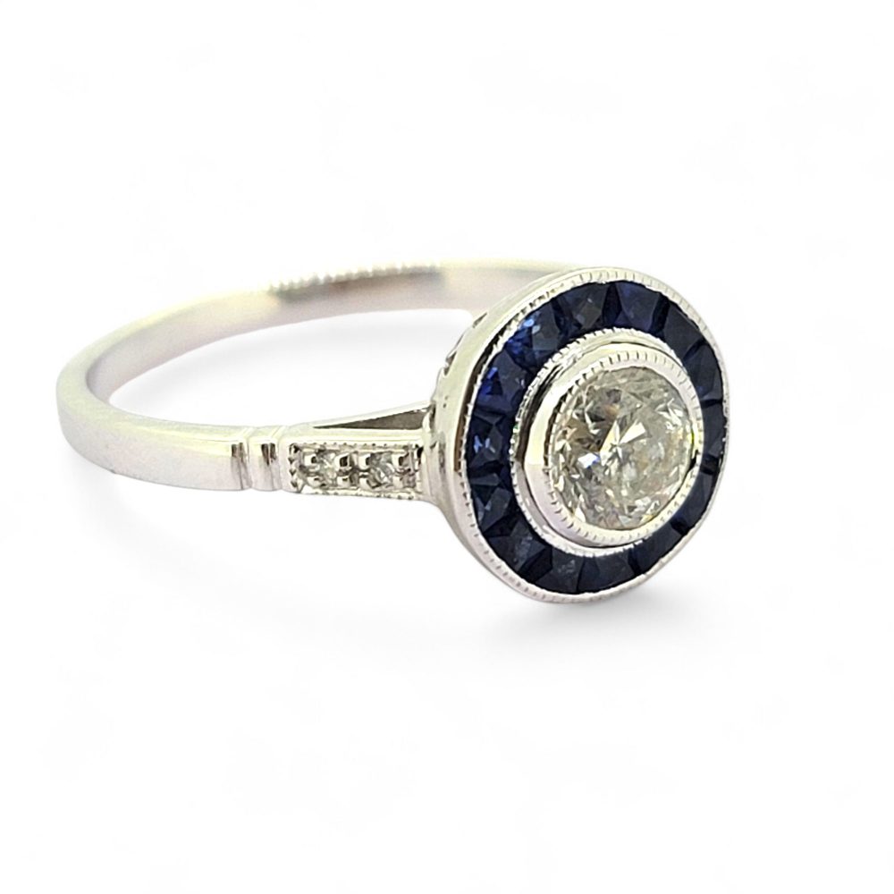 0.53ct Diamond and Sapphire Target Engagement Ring, 0.53ct round brilliant-cut diamonds surrounded by a halo of calibre sapphires in 18ct white gold