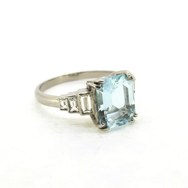 Aquamarine and Baguette Diamond Dress Ring in Platinum, central 2.60ct emerald-cut aquamarine flanked either side by three graduated baguette-cut diamonds