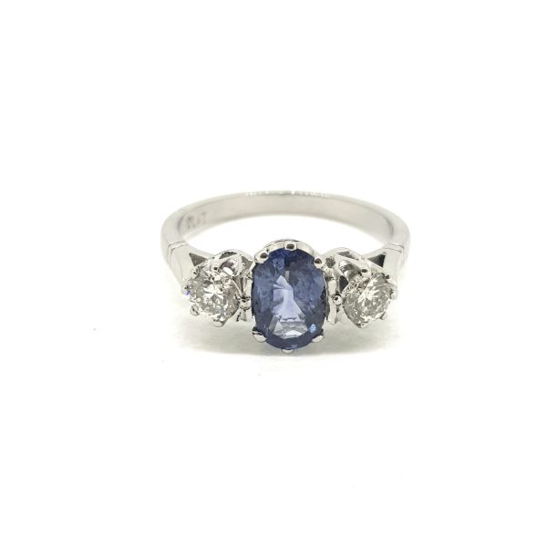 Sapphire and Diamond Three Stone Ring in Platinum; central 1.10ct oval sapphire flanked by 0.65cts diamonds