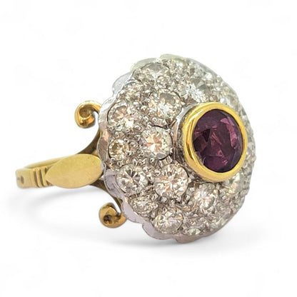Ruby and Diamond Bombe Cluster Ring, central red ruby sits atop a domed bombe cluster of sparkling diamonds in white gold to an 18ct yellow gold shank with decorative scrolled shoulders
