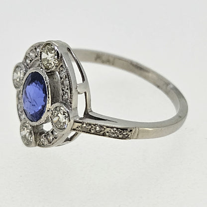 An oval sapphire and round diamond open cluster ring in platinum
