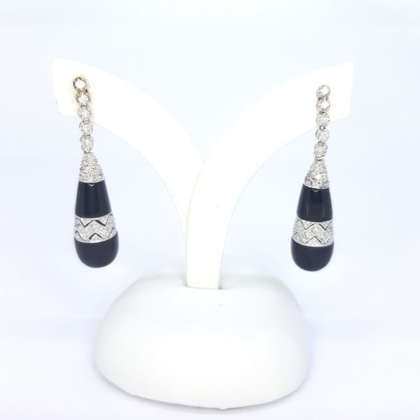 Contemporary Onyx and Diamond Drop Earrings; teardrop shaped onyx with diamond accents, suspended from graduated diamond set drops, in 18ct white gold