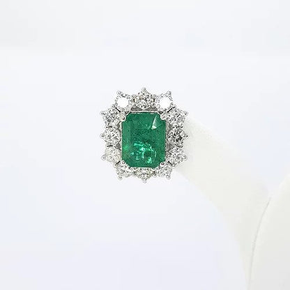 Emerald Cut Emerald and Diamond Cluster Stud Earrings; 4.25cts emerald-cut emeralds surrounded by 2.30cts round brilliant-cut diamonds, in 18ct white gold