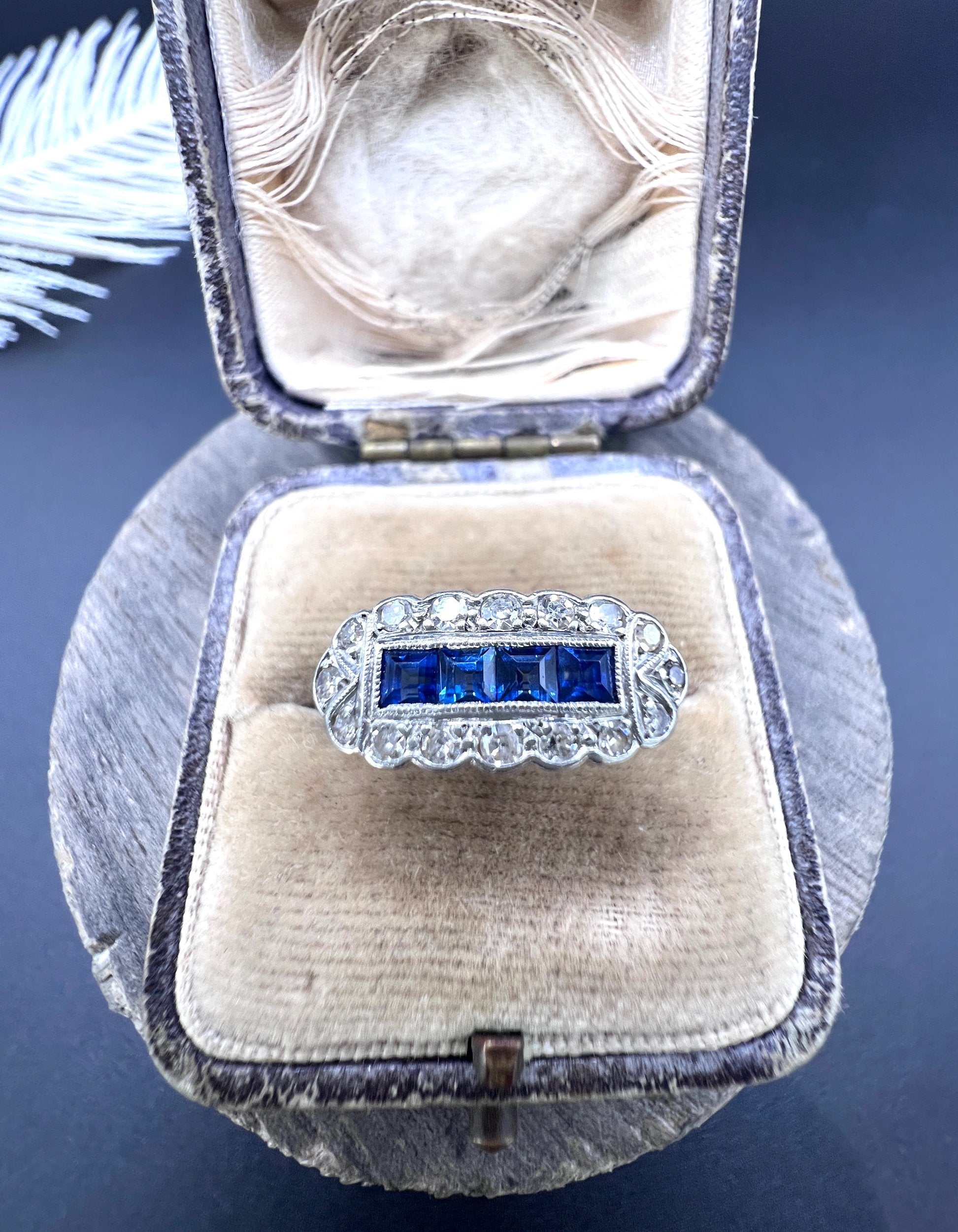 A sapphire and diamond elongated cluster ring in platinum and yellow gold, in an antique ring box