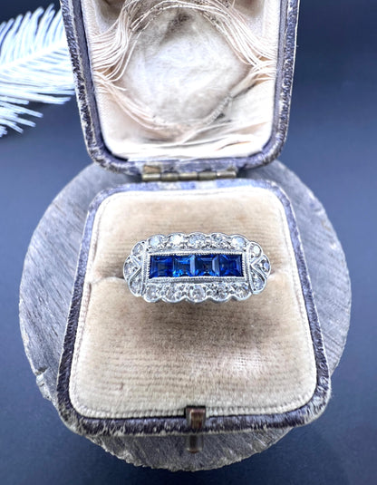A sapphire and diamond elongated cluster ring in platinum and yellow gold, in an antique ring box