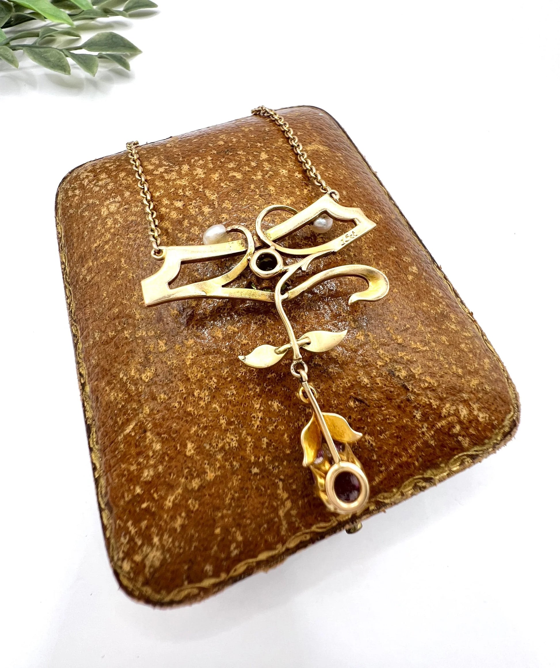 A yellow gold pendant necklace with pearls, a peridot, a diamond and a pink tourmaline drop