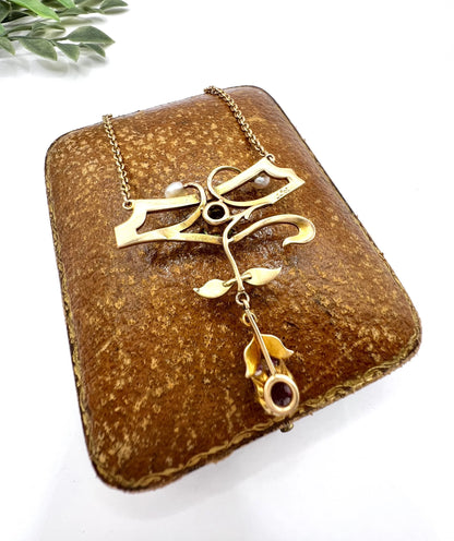 A yellow gold pendant necklace with pearls, a peridot, a diamond and a pink tourmaline drop