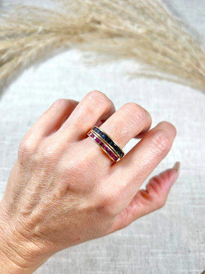 A yellow gold ruby channel set eternity band, modelled on a hand