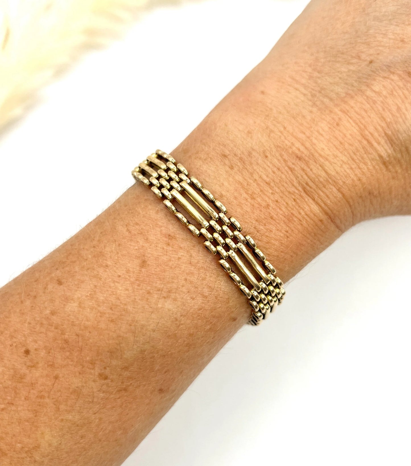 A yellow gold gate bracelet, modelled on a wrist