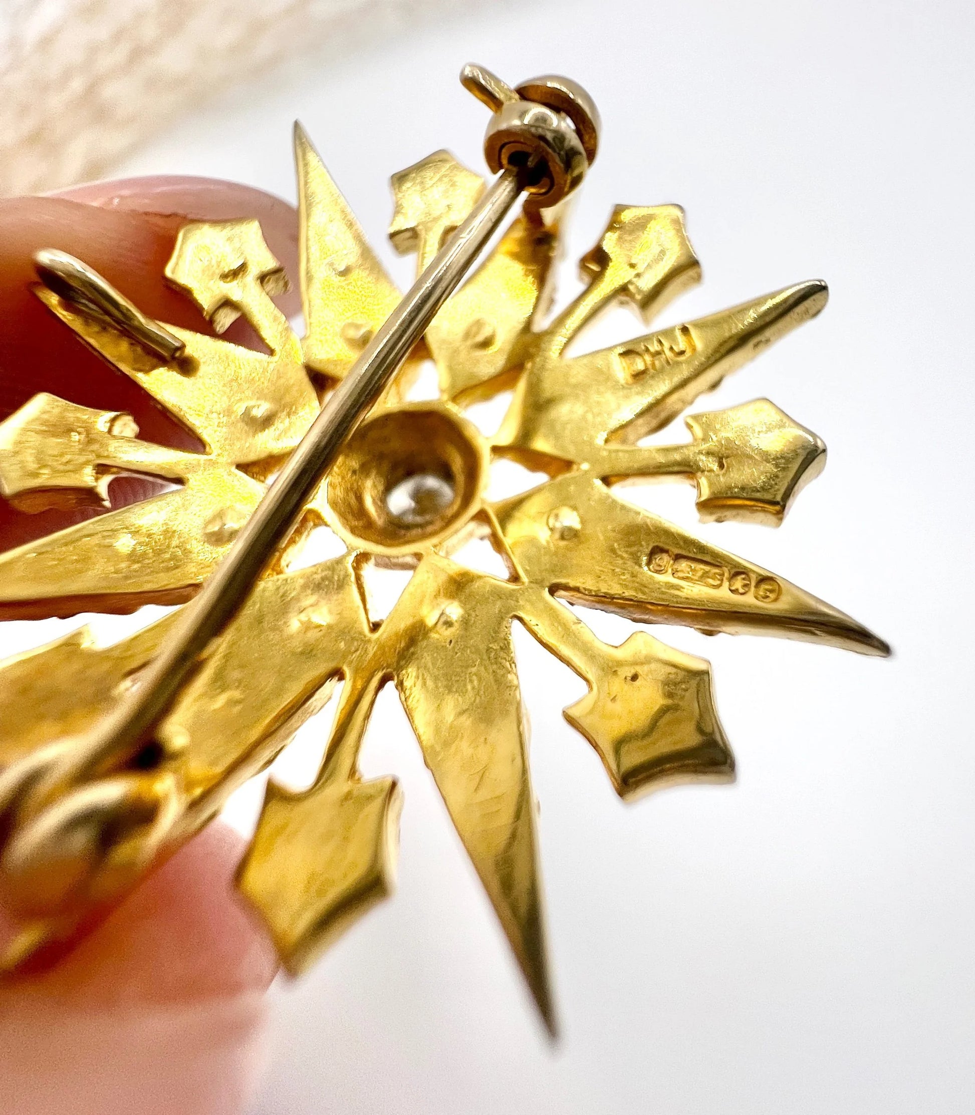A hallmark on a yellow gold star-shaped brooch/pendant