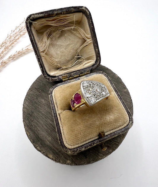 A diamond and ruby buckle design ring in gold and platinum, in a ring box