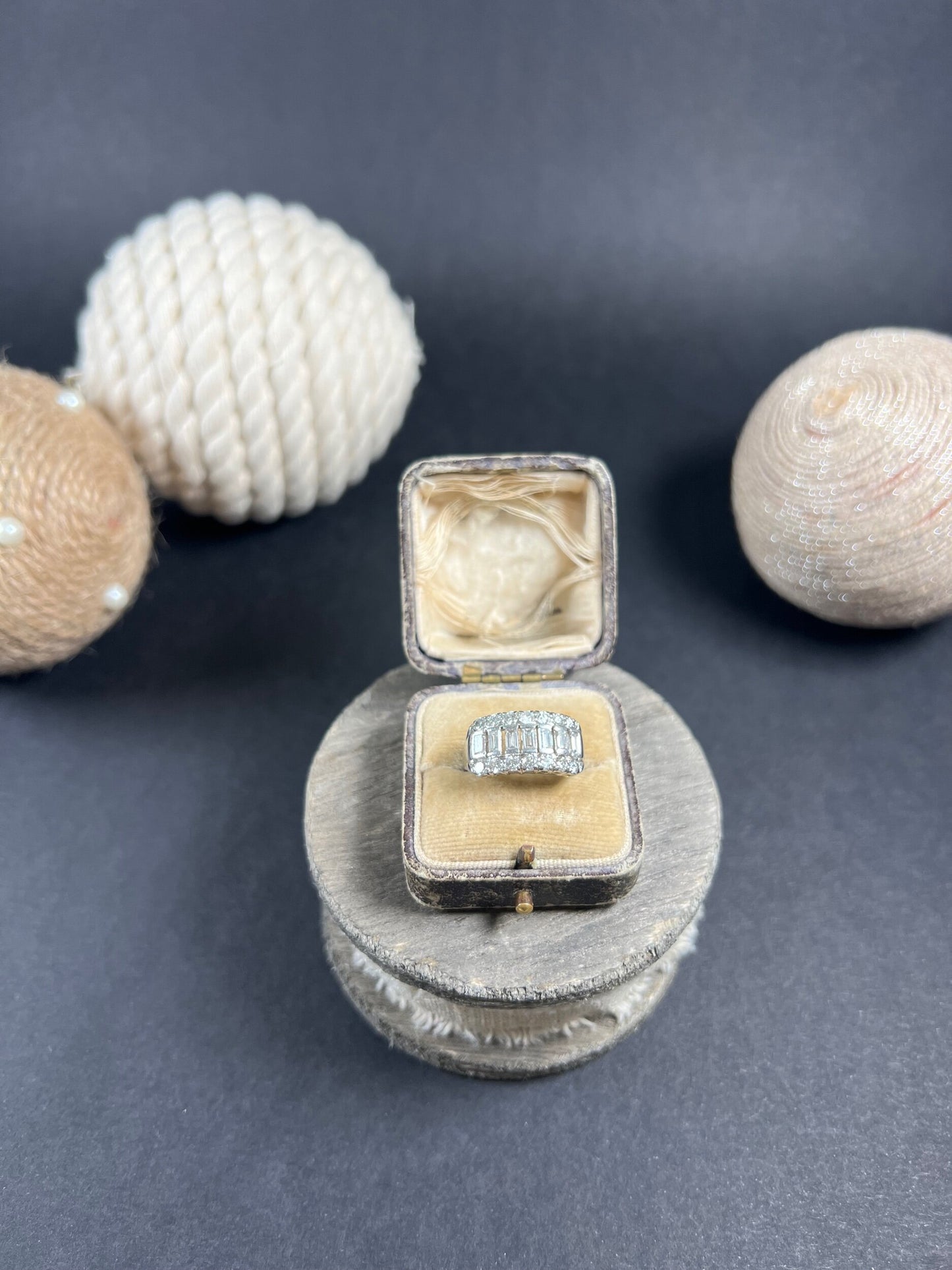 A three row diamond band ring in platinum in an antique ring box
