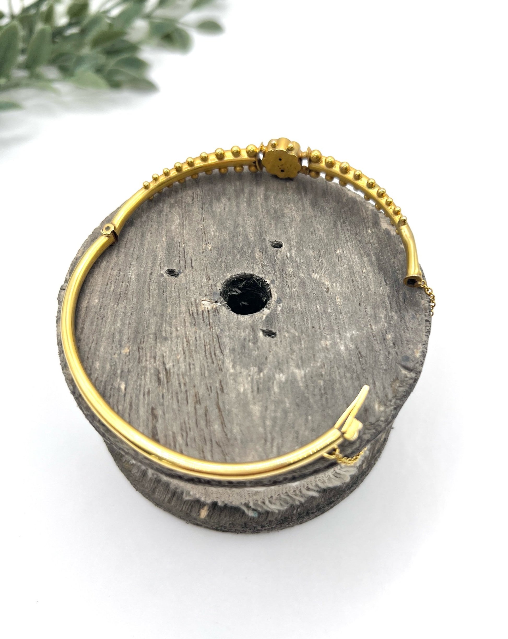 A yellow gold bangle bracelet set with rubies and seed pearls