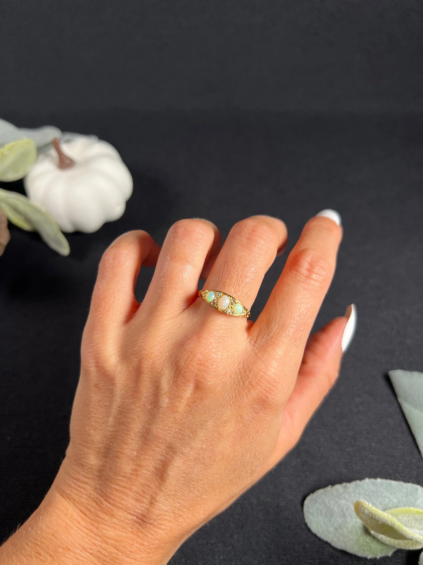 A boat-shaped gold ring with opals and diamonds, modelled on a hand