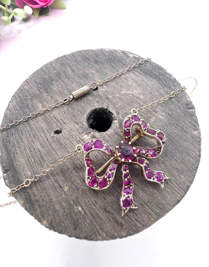 A ruby bow brooch necklace in gold and silver