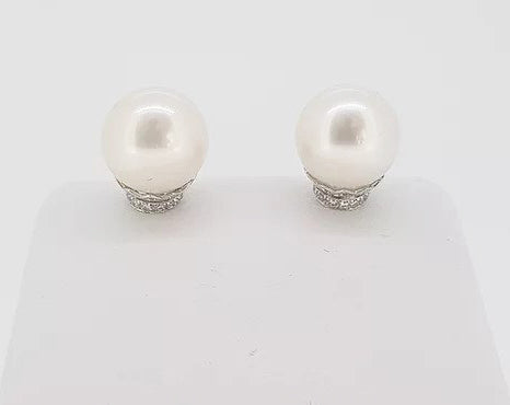 Pearl and Diamond Stud Earrings; featuring cultured pearl studs accented with micro-set diamond collars. Mounted in 18ct white gold.