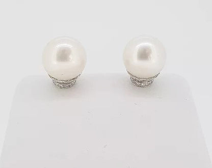 Pearl and Diamond Stud Earrings; featuring cultured pearl studs accented with micro-set diamond collars. Mounted in 18ct white gold.
