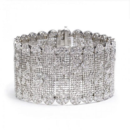 Diamond Tapestry Bracelet in Platinum; set with 14.62 carats of round old-cut and single-cut diamonds, in a sweeping floral pattern depicting flowers and leaves upon a branch, with scalloped edges