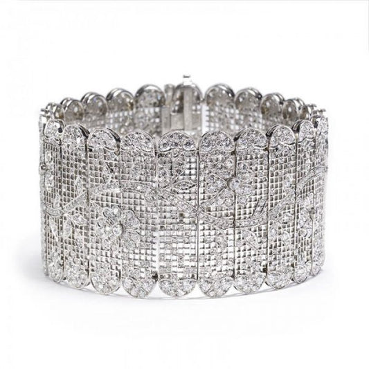 Diamond Tapestry Bracelet in Platinum; set with 14.62 carats of round old-cut and single-cut diamonds, in a sweeping floral pattern depicting flowers and leaves upon a branch, with scalloped edges