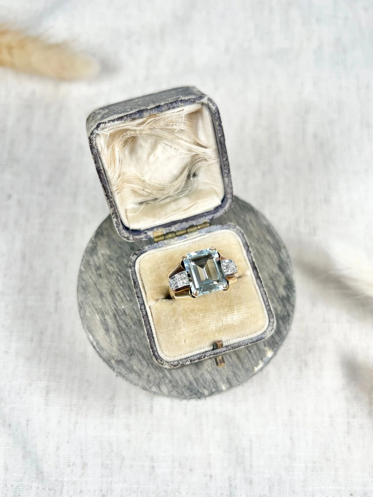 An aquamarine and diamond cocktail ring in gold, in an antique ring box