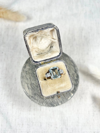 An aquamarine and diamond cocktail ring in gold, in an antique ring box