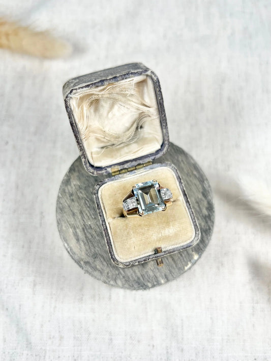 An aquamarine and diamond cocktail ring in gold, in an antique ring box