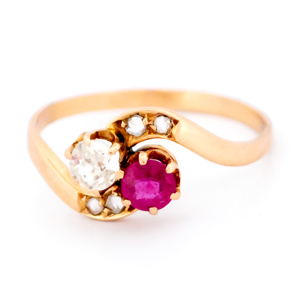 A two stone crossover ring in yellow gold with a ruby and diamonds