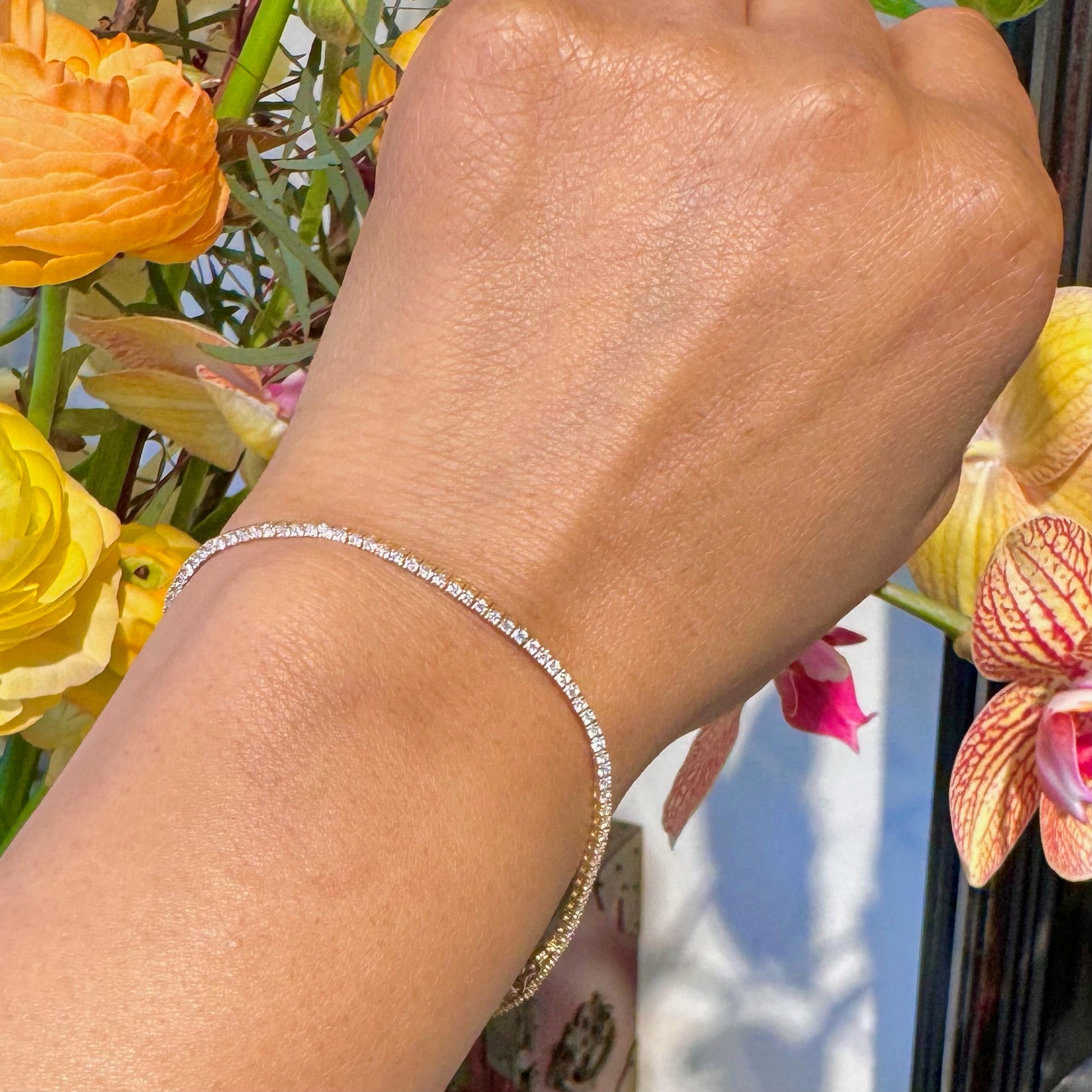 A yellow gold diamond line bracelet, modelled on a wrist