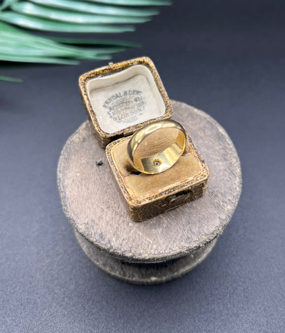 A single stone old cut diamond gypsy band ring in yellow gold