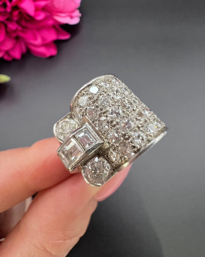 A round and square diamond tank style cocktail ring in platinum, held in a hand