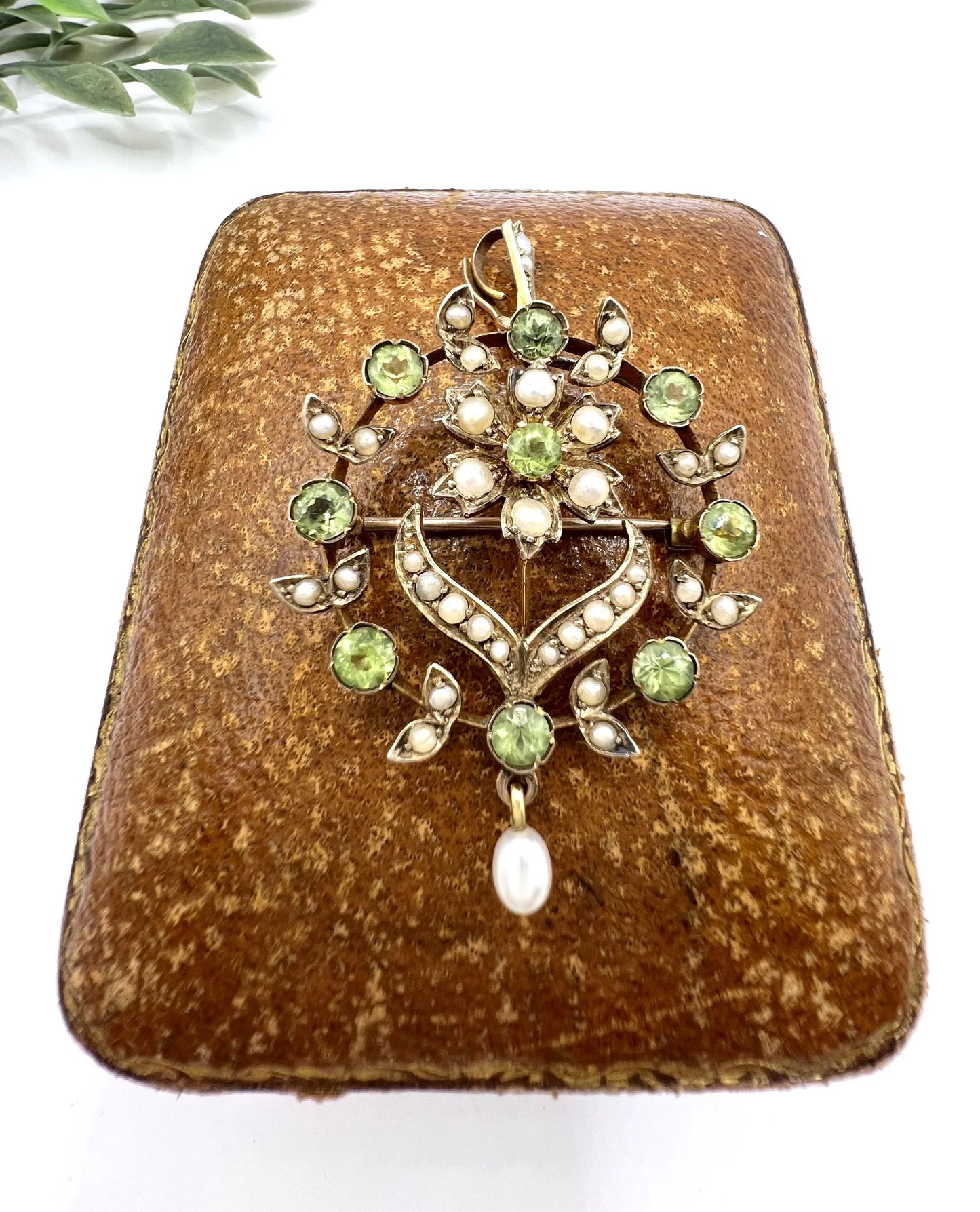 A peridot and pearl floral circle brooch/pendant in yellow gold