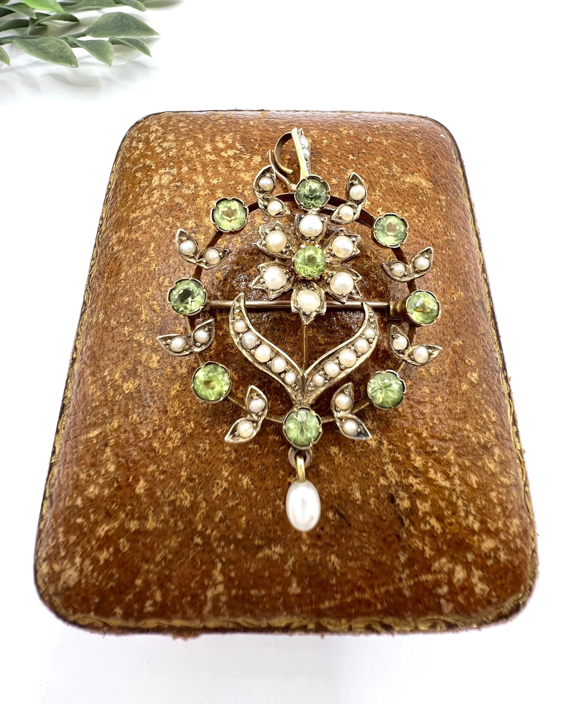 A peridot and pearl floral circle brooch/pendant in yellow gold