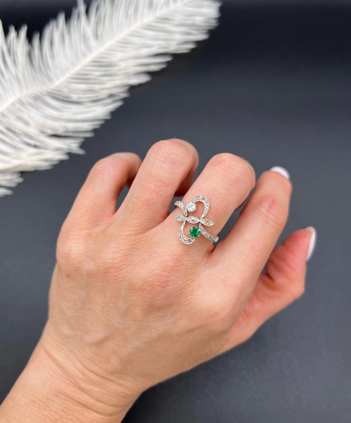 An emerald and diamond fancy openwork ring in yellow gold and platinum, modelled on a hand