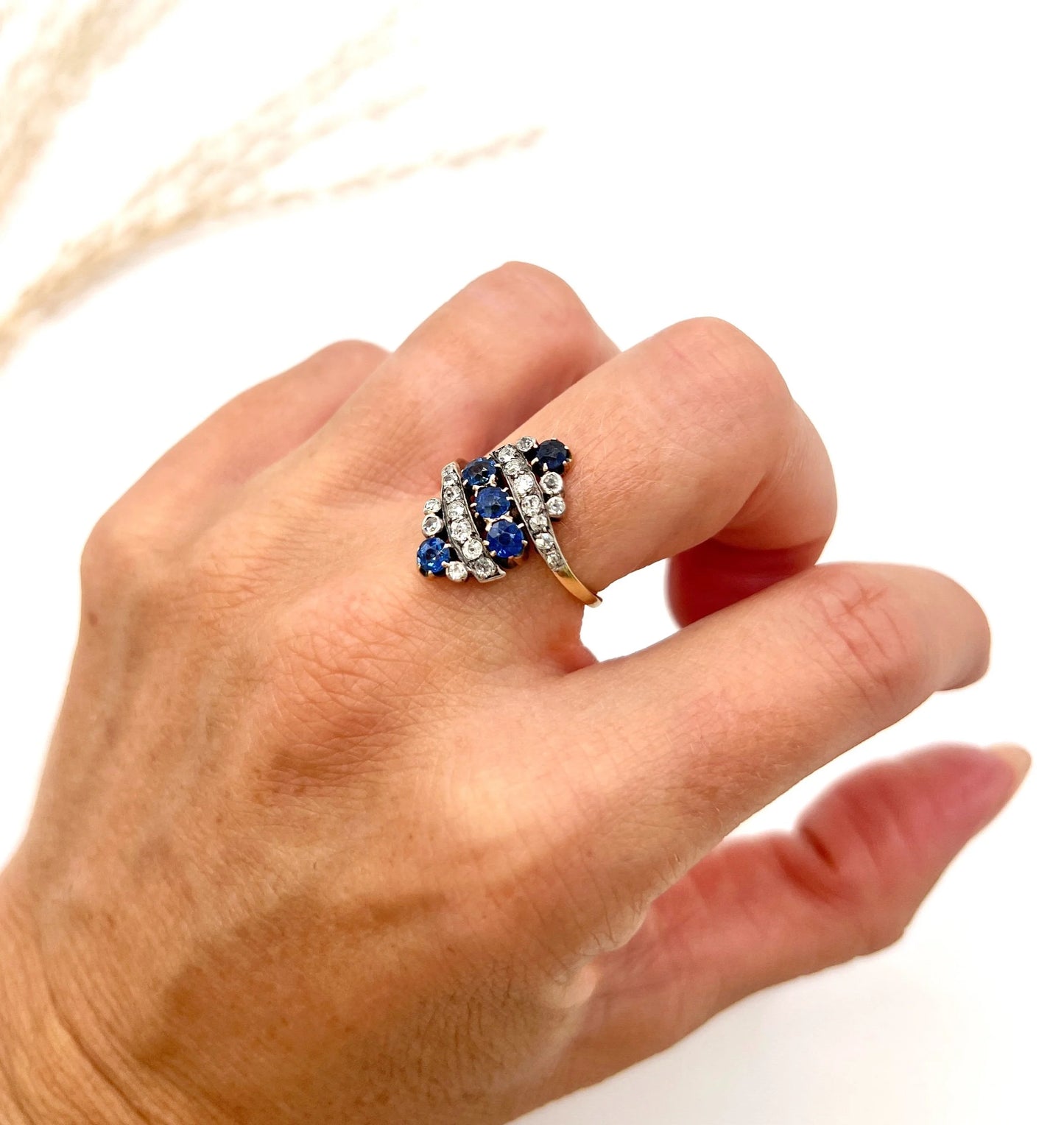 A navette shaped sapphire and diamond ring in yellow gold, modelled on a hand