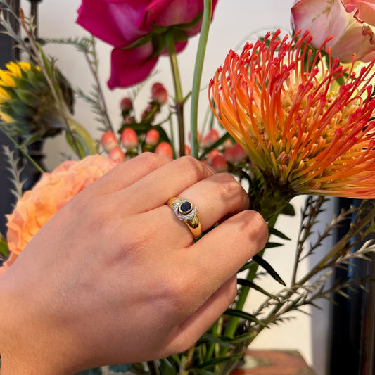 A sapphire and diamond ring in yellow and white gold, modelled on a hand
