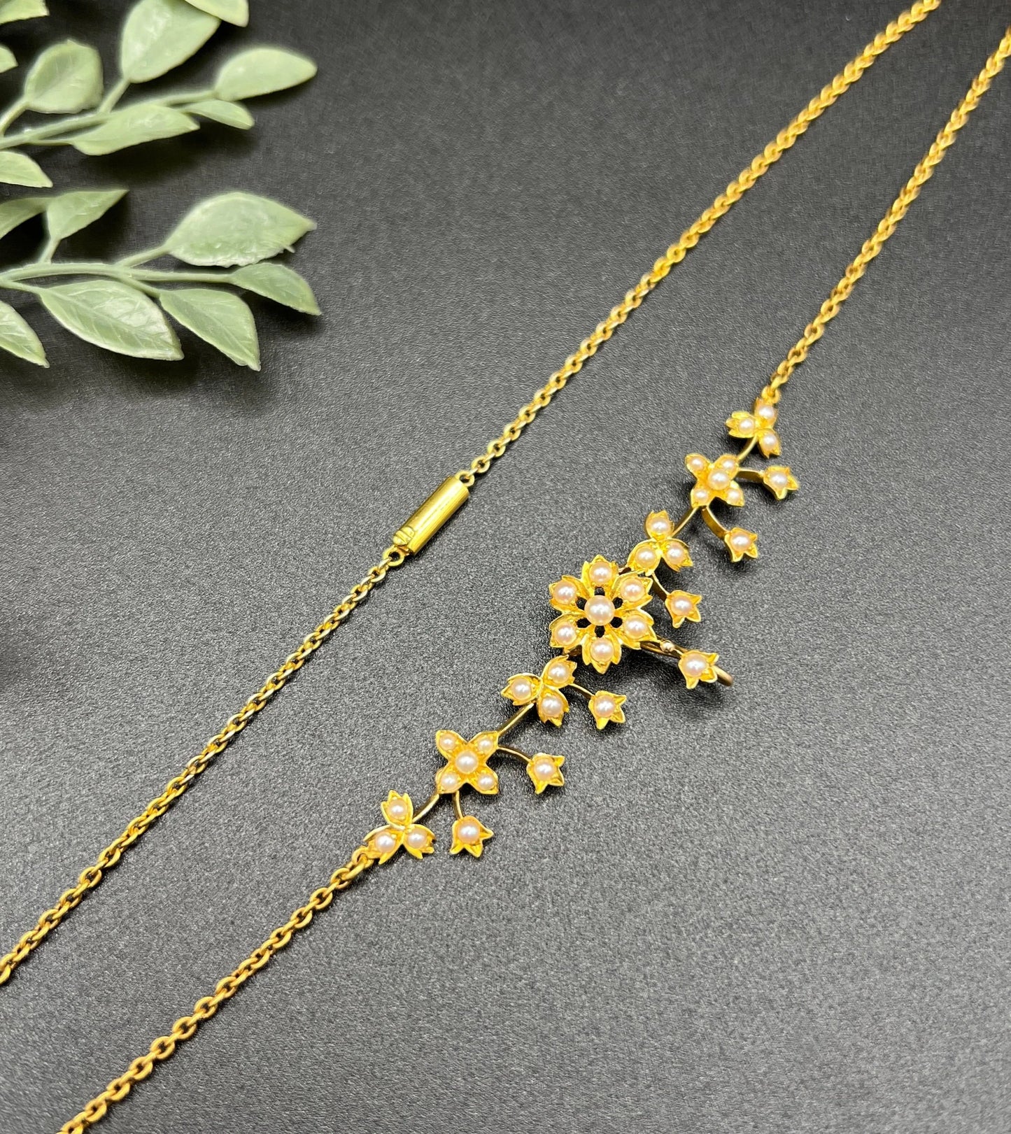 A yellow gold floral pendant necklace with seed pearls