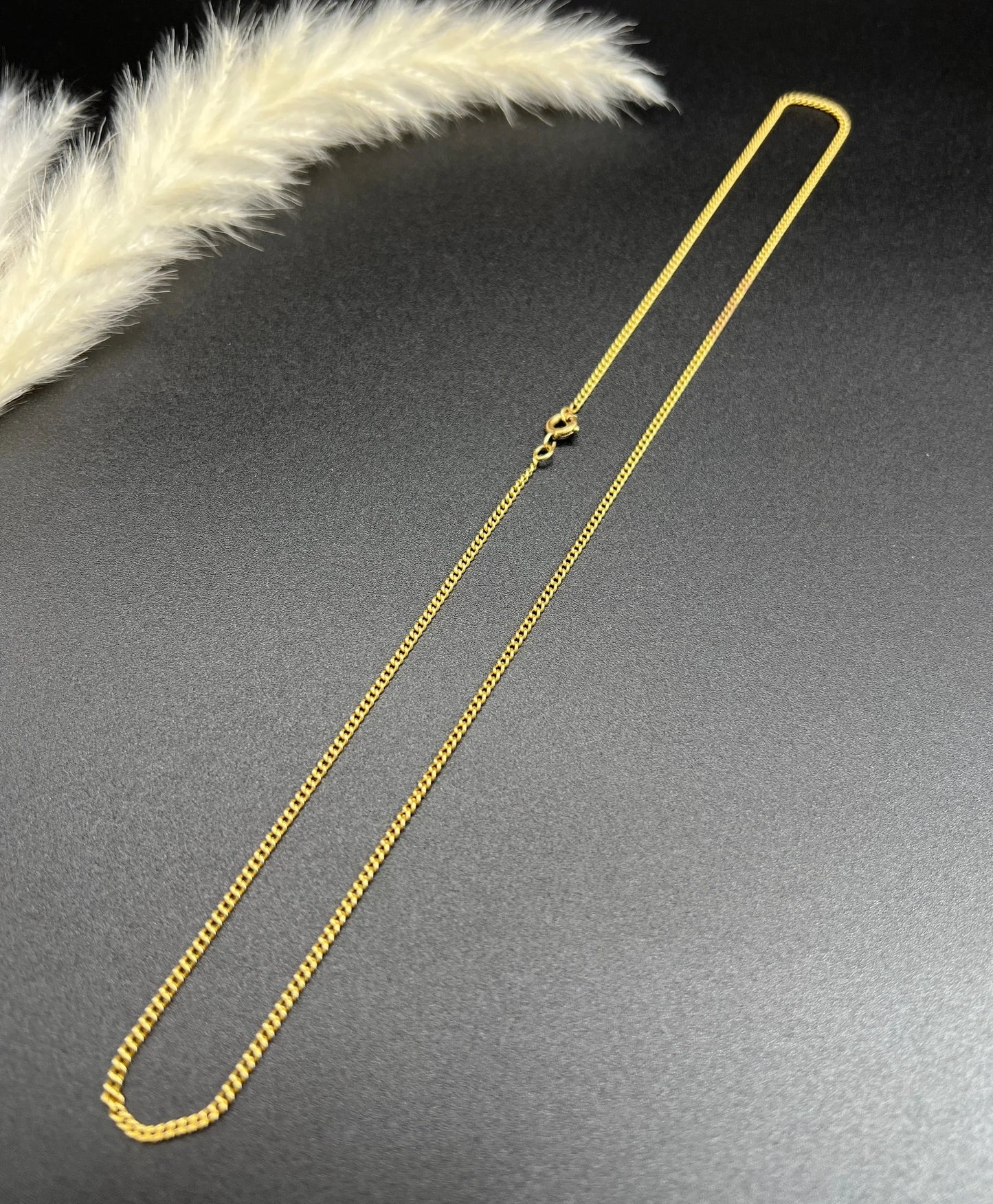 A fine curb link chain necklace in yellow gold