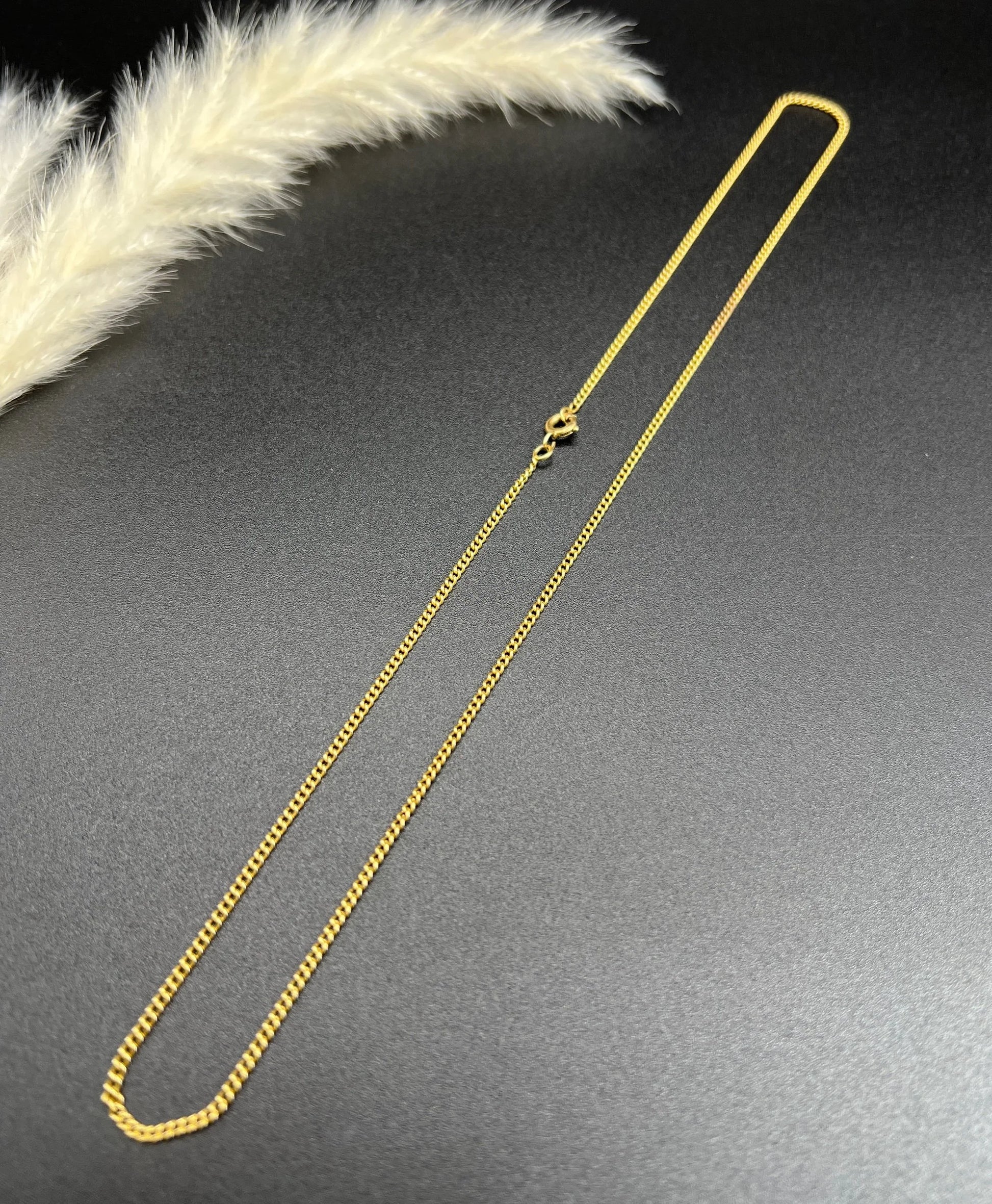 A fine curb link chain necklace in yellow gold