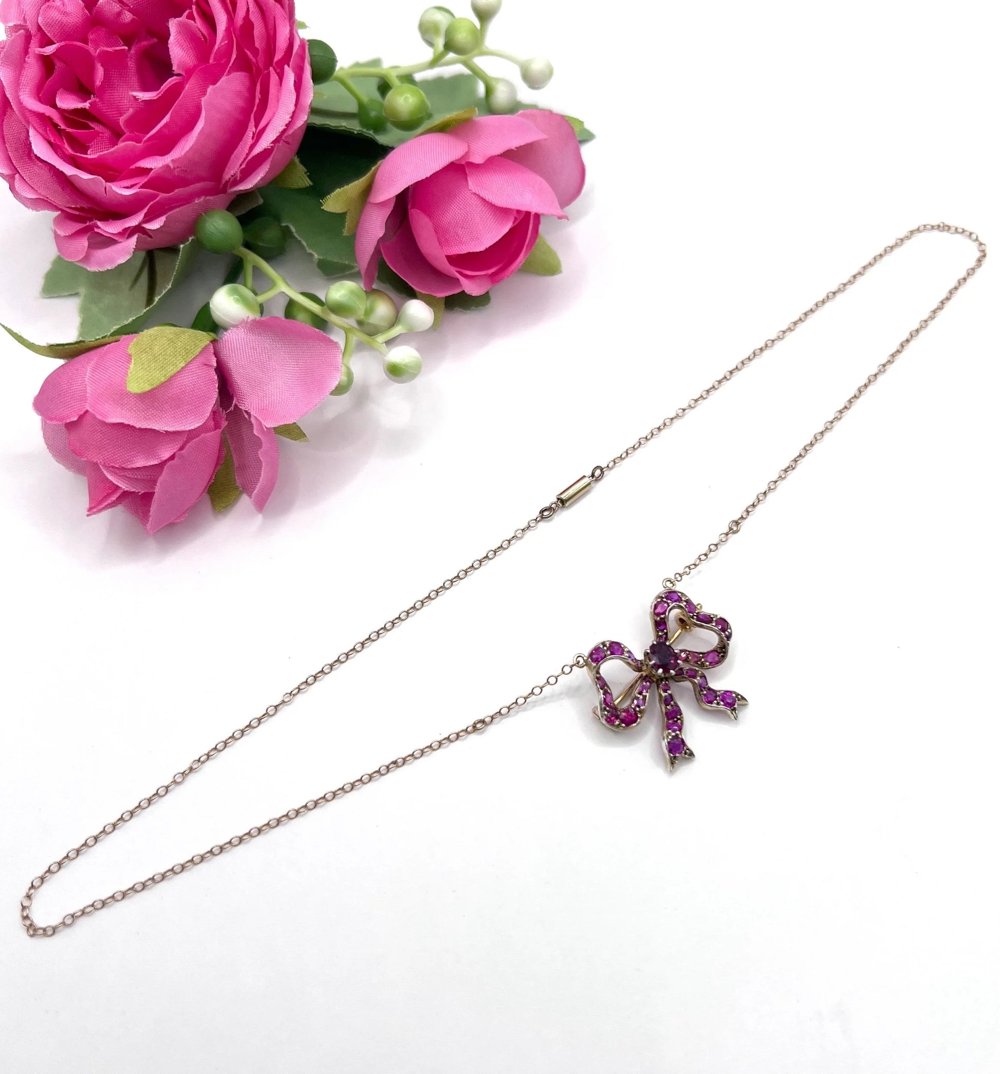 A ruby bow brooch necklace in gold and silver
