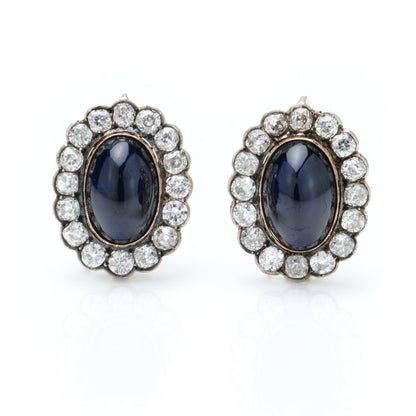 Antique Russian Cabochon Sapphire and Old Cut Diamond Cluster Earrings; 12cts cabochon blue sapphires surrounded by 6.40cts old-cut diamonds, in 14ct yellow gold with post and clip fittings, Circa 1850s