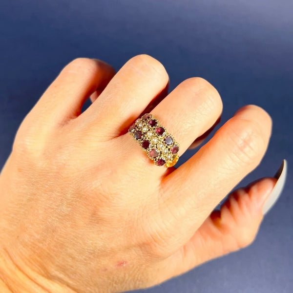 A yellow gold triple row ring with garnets and seed pearls, modelled on a hand