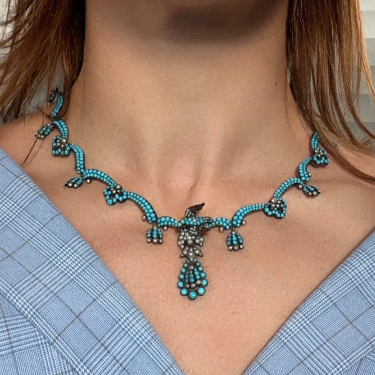 An antique turquoise bead and pearl fancy necklace with a bird motif, modelled on a neck