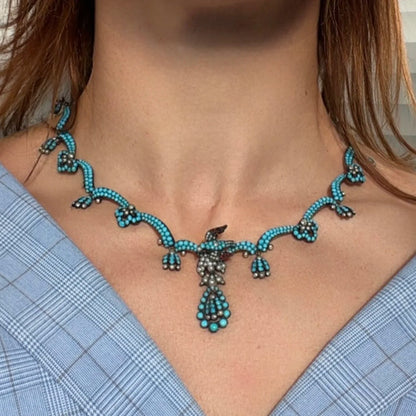 An antique turquoise bead and pearl fancy necklace with a bird motif, modelled on a neck