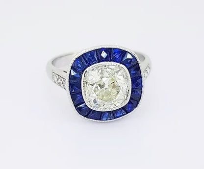 1.96ct Diamond and Sapphire Target Cluster Ring; central diamond surrounded by calibre-cut sapphires, collet-set, diamond set shoulders, 18ct white gold.