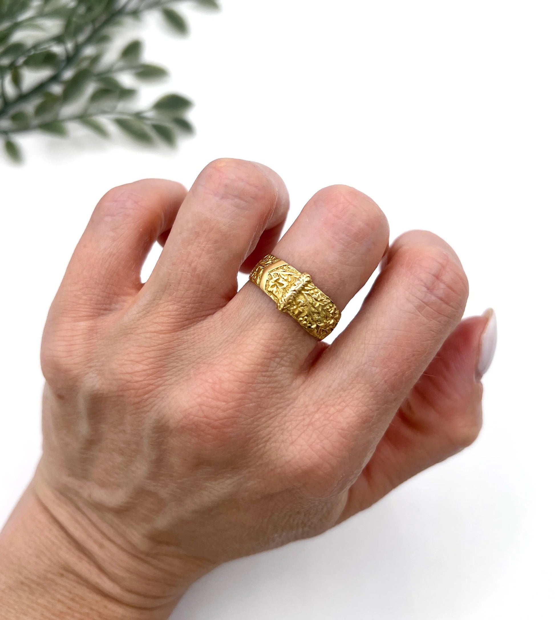 A yellow gold ornate engraved buckle band ring, modelled on a hand