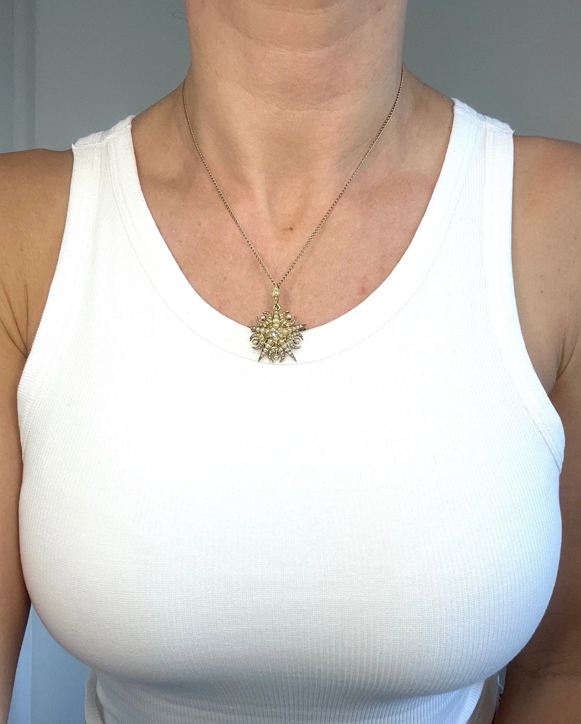 A yellow gold star and crescent brooch/pendant with pearls and a diamond centre, with a chain, modelled