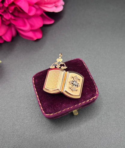 A yellow gold ornate locket with diamond fleur-de-lis detail, open
