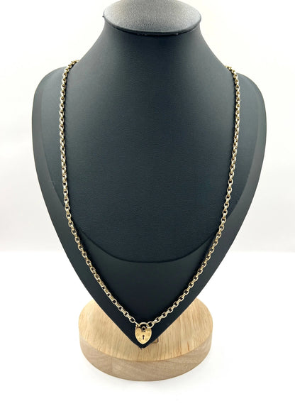 A gold belcher link chain with a heart shaped padlock clasp pendant, on a black jewellery bust